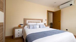 a bedroom with a large bed with two blue pillows at Terraza del atardecer in Vilar +18 photos
