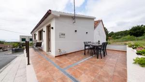 a house with a patio with a table and chairs at Terraza del atardecer in Vilar