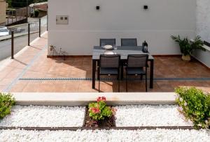 a patio with a table and chairs in a yard at Terraza del atardecer in Vilar