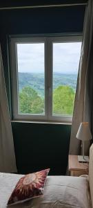 a bedroom with two windows and a bed with a pillow at La Maison d'Osquich in Musculdy