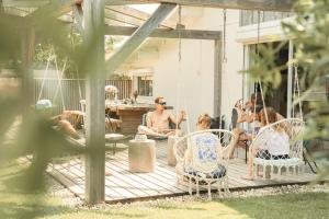 a group of people sitting on a porch swing at La Maison Bisca in Biscarrosse-Plage