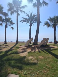 a park with palm trees on the beach at Apto a 2 minutos de playa. in Fuengirola
