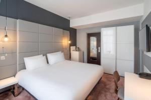 a bedroom with a large white bed and a desk at Best Western Dijon Centre Gare in Dijon