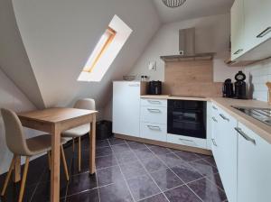 a kitchen with white cabinets and a wooden table at PM09 KüstenReich in Wremen +13 photos