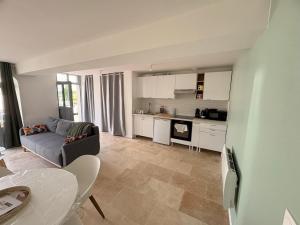 a living room with a couch and a kitchen at Entre Loire & Château in Chaumont-sur-Loire