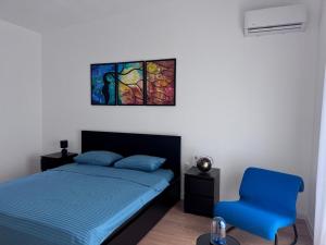 a bedroom with a bed and a blue chair at Villa Oaza in Bar