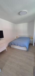 a bedroom with a bed and a dresser with a tv at Studio between city and countryside in Lompret