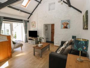 a living room with a couch and a table at Daffodil Cottage in Treorky