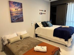 a bedroom with two beds and a couch in it at Resort de Luxo em Muro Alto - Porto de Galinhas in Ipojuca +30 photos