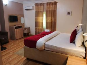 a hotel room with a bed and a television at Marrisson Residence in Abuja