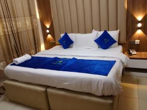 a large bed in a hotel room with blue pillows at Marrisson Residence in Abuja