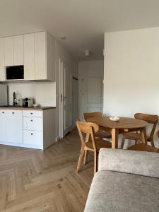 a living room with a table and a kitchen at Brzeg in Kuźnica