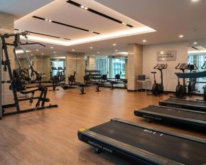 a gym with several treadmills and machines in a room at Zcape garden by lsqstays in Ban Rangeng