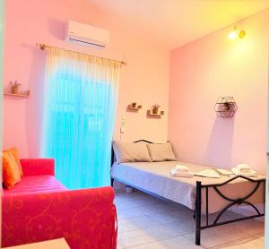 a room with a bed and a couch and a table at Shell-paralia ofriniou in Ofrínion