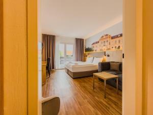 a hotel room with a bed and a couch at Hotel Sachsengang - free parking, near U1 & U2 in Groß-Enzersdorf +49 photos