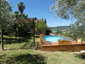 a swimming pool in a yard with a wooden deck at Scappo in Umbria, L'antico casale in Narni