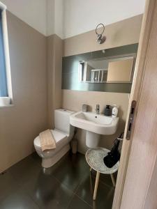 a bathroom with a white toilet and a sink at Pebble Home in Yialós