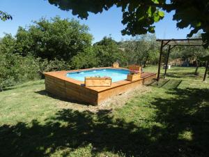 a pool in a yard with a wooden deck at Scappo in Umbria, L'antico casale in Narni