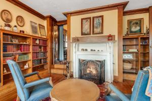 a living room with a fireplace and a table and chairs at Prospect Hill on Main in Waynesville