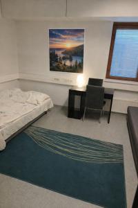 a bedroom with a bed and a desk and a table at Office House Tripla in Helsinki