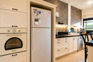 a kitchen with a white refrigerator in a kitchen at Carmel Home Mount Seaview in Haifa