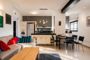 a living room and kitchen with a couch and a table at Carmel Home Mount Seaview in Haifa
