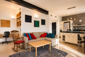 a living room with a couch and a kitchen at Carmel Home Mount Seaview in Haifa