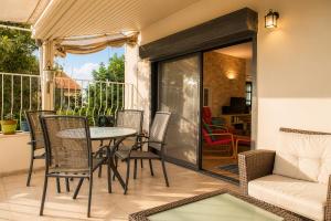 a patio with a table and chairs and a couch at Carmel Home Mount Seaview in Haifa