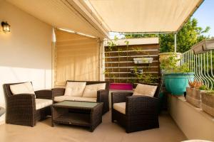 a patio with wicker chairs and a couch and a table at Carmel Home Mount Seaview in Haifa +8 photos
