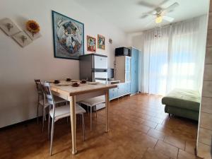 a kitchen and dining room with a table and chairs at Condominio Aquila in Bibione +12 photos