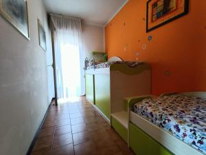 a bedroom with a bed and an orange wall at Condominio Aquila in Bibione