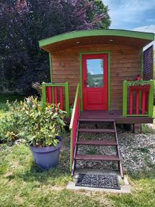 a play house with two chairs and a ladder in front of it at Roulotte Anaîs in Grandcourt +4 photos