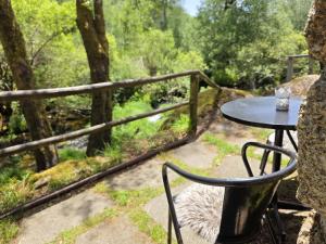 a table and a chair sitting on a patio at Moinhos do Poço Verde in Castro Laboreiro +51 photos