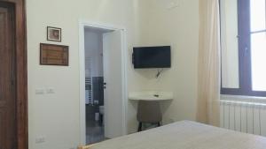 a bedroom with a sink and a television on the wall at AmMARE in Crotone