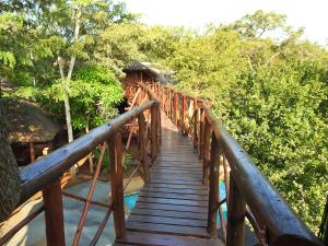 a wooden bridge leading to a cabin in the woods at Bona Ngwenya Lodge & Safaris in Marloth Park