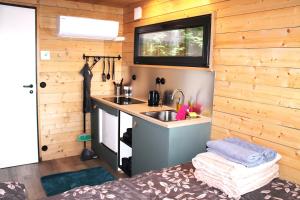a kitchen in a tiny house with a sink at PRIVAATNE Metsamajake SAUNAGA "VULIN" in Sigula +4 photos