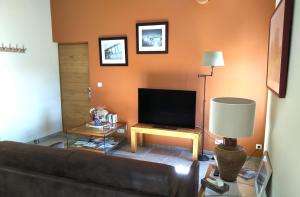 a living room with a couch and a television at Mas des Treilles - Chambre d'hôtes - Côté Campagne in Mane