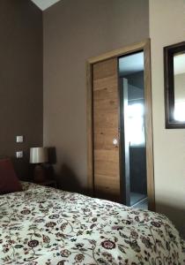 a bedroom with a bed with a flowered comforter at Mas des Treilles - Chambre d'hôtes - Côté Campagne in Mane
