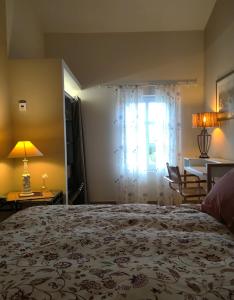 a bedroom with a bed and a table and a window at Mas des Treilles - Chambre d'hôtes - Côté Campagne in Mane