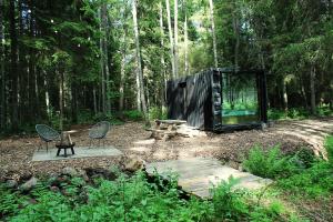 a tent in the woods with two chairs and a picnic table at PRIVAATNE Metsamajake SAUNAGA "VULIN" in Sigula