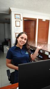 a woman is standing in front of a computer at Hotel El Principe in Ocaña