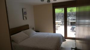 a bedroom with a bed and a sliding glass door at Casa Leo in Cee