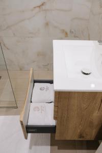 a bathroom with a white sink and a counter with towels at Centralin Apartotel in Tirana +69 photos