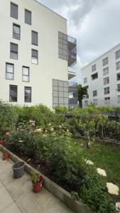 a garden in front of a building with plants at Une petite chambre cosy in Dijon