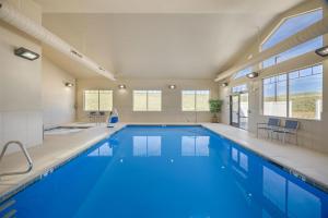 a large swimming pool with blue water in a building at Best Western PLUS Fossil Country Inn & Suites in Kemmerer