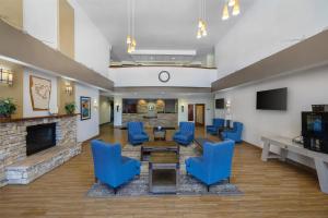 a living room with blue chairs and a fireplace at Best Western PLUS Fossil Country Inn & Suites in Kemmerer