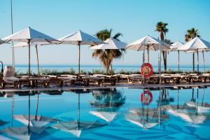 a swimming pool with tables and umbrellas at MS Amaragua in Torremolinos