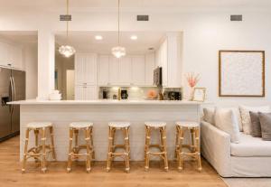 a living room with a couch and a kitchen at The Palm Beach House - Tropical in Palm Beach +29 photos