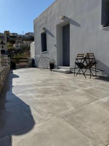 a patio with two chairs and a building at Bamboo House Syros No1 in Ermoupoli