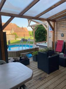 a patio with a swimming pool and a table and chairs at Juste un rayon de soleil Maison 6 personnes Alsace Centrale Proche Europa-park in Saasenheim